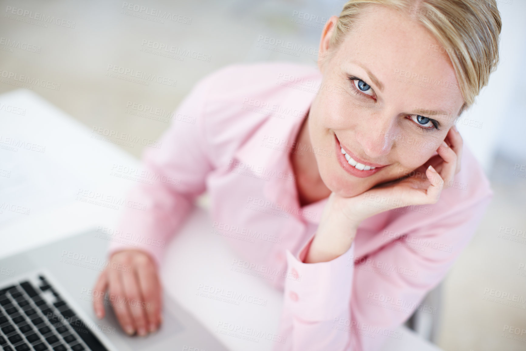 Buy stock photo Portrait of a young blond woman sitting at her desk with a laptop