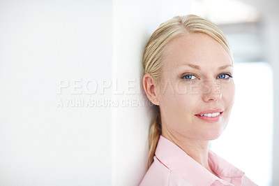 Buy stock photo Closeup shot of an attractive young businesswoman leaning against a wall