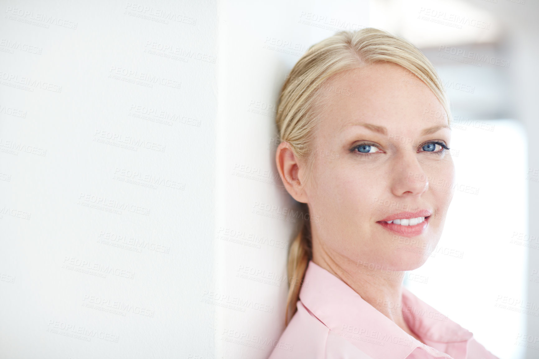 Buy stock photo Closeup shot of an attractive young businesswoman leaning against a wall