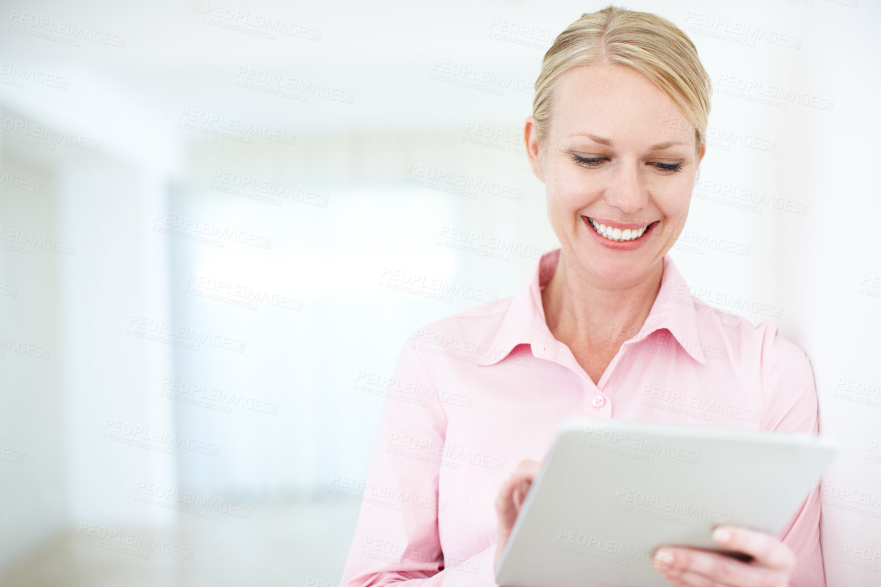 Buy stock photo An attractive businesswoman looking at something on her digital tablet