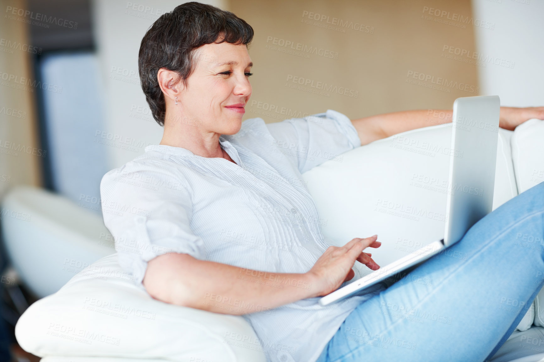 Buy stock photo Mature business woman sitting on couch using laptop