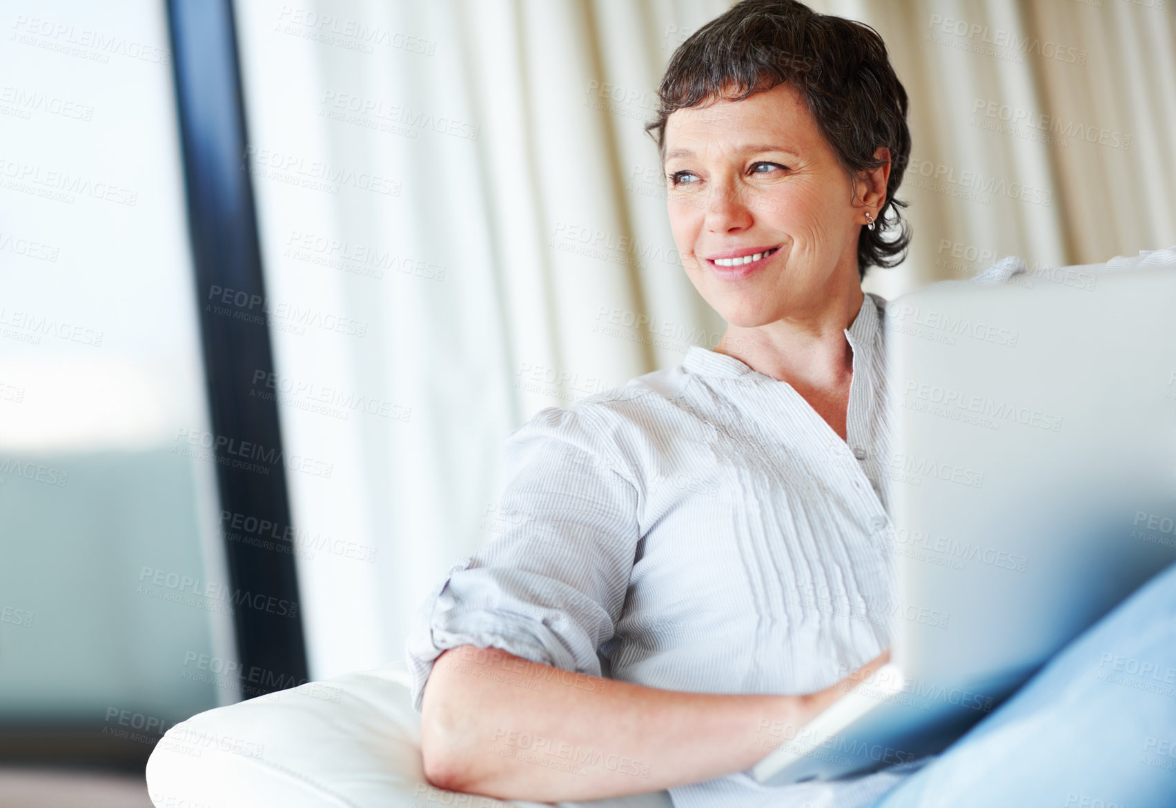 Buy stock photo Thoughtful mature business woman sitting on couch using laptop