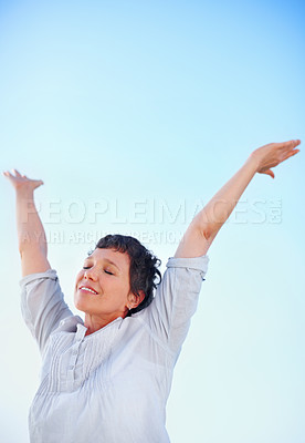 Buy stock photo Low angle view attractive mature woman enjoying freedom outdoors with arms outstretched