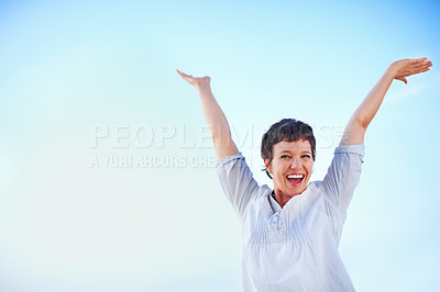 Buy stock photo Playful mature female enjoying freedom against sky with hands outstretched
