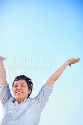 Buy stock photo Low angle view attractive mature woman enjoying freedom against sky with arms outstretched