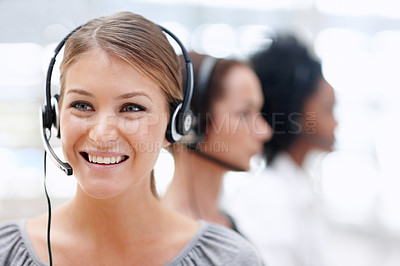 Buy stock photo Happy call operator wearing a headset while sitting with colleagues