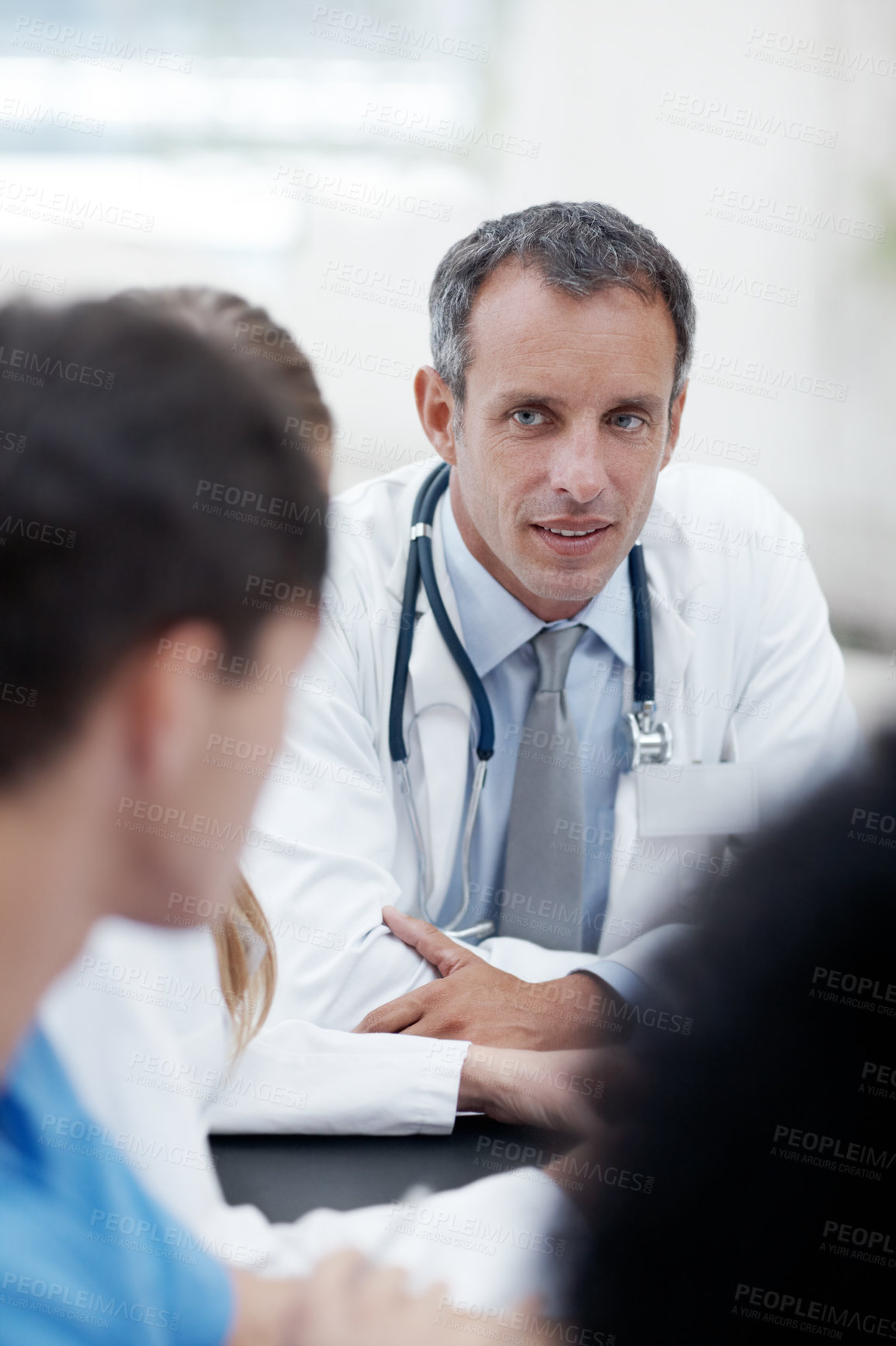 Buy stock photo Doctors, man and meeting with group at hospital with review, report and career in healthcare. People, discussion and scrum in boardroom at clinic for wellness, services and listening for feedback