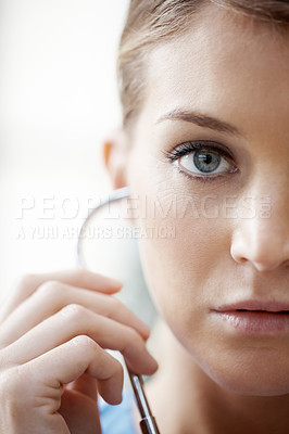 Buy stock photo Cropped image of a beautiful female doctor listening through a stethoscope - closeup