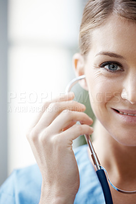Buy stock photo Cropped image of a beautiful smiling female doctor listening through a stethoscope - closeup