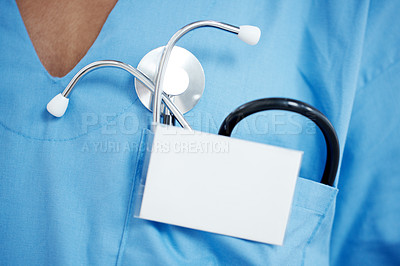 Buy stock photo Cropped image of a stehoscope in a doctor's pocket with a blank ID badge in front of it