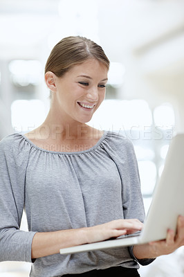 Buy stock photo A beautiful young woman using her laptop in the office