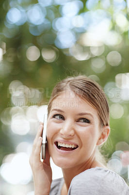 Buy stock photo A happy young woman speaking on her cellphone