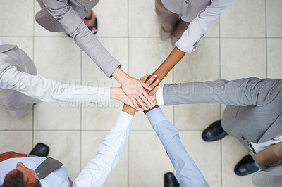 Buy stock photo Top view of six diverse colleagues putting their hands together in union