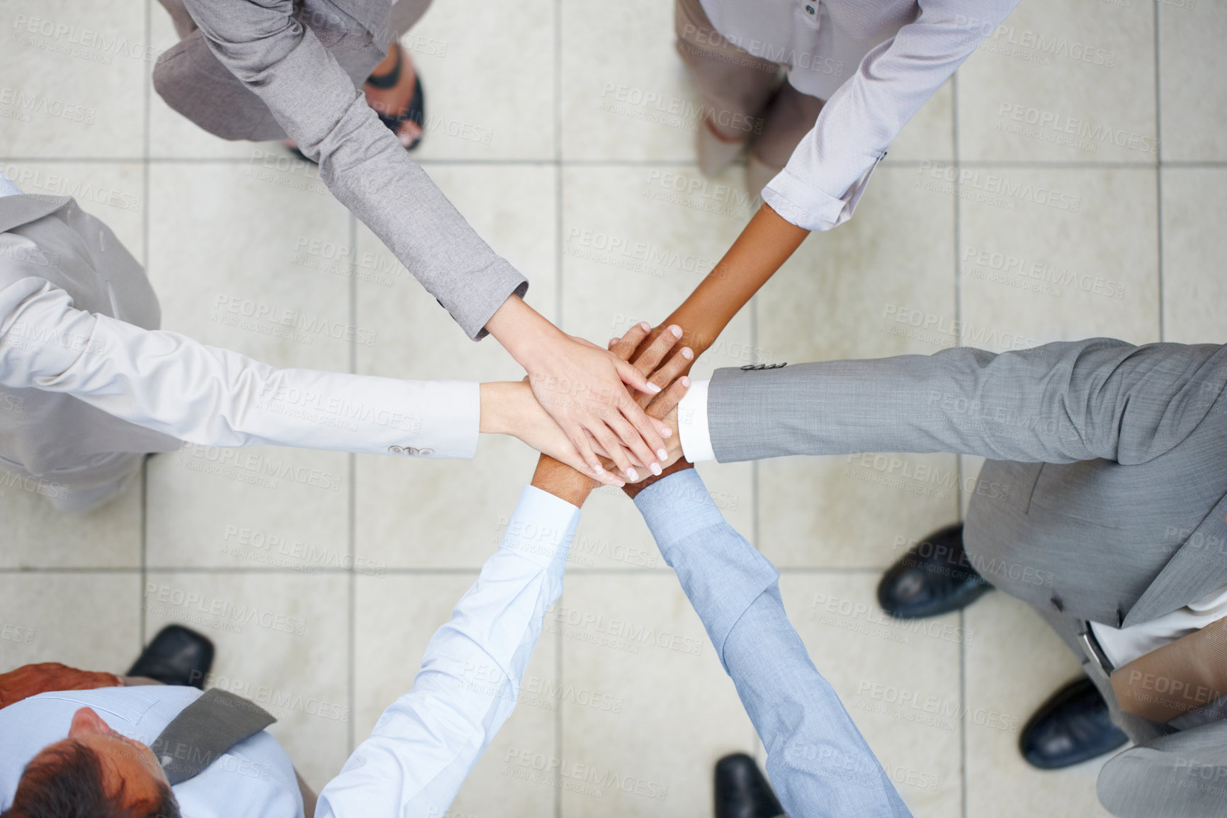 Buy stock photo Top view of six diverse colleagues putting their hands together in union