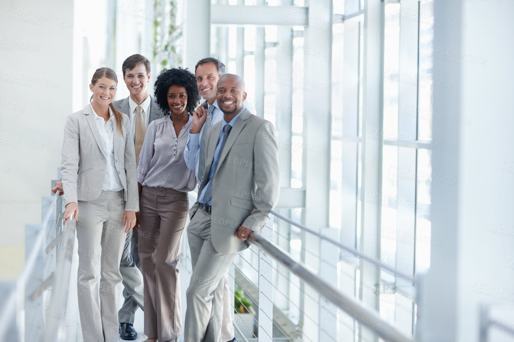Buy stock photo Dynamic group of colleagues stand in their workplace while looking at you - Copyspace