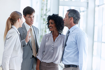 Buy stock photo Four business colleagues catch up on office gossip
