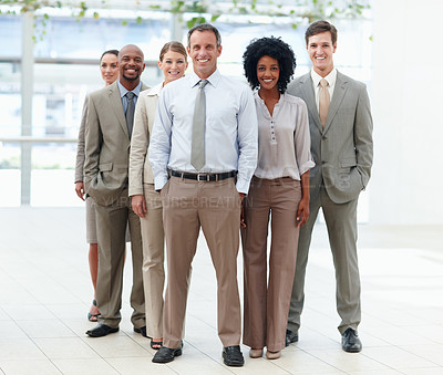 Buy stock photo Full length of a diverse business team standing confidently with their team leader