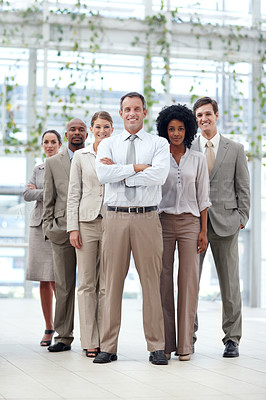 Buy stock photo Full length of a dynamic business team standing confidently with their team leader - Copyspace