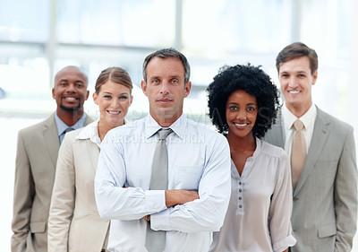 Buy stock photo Business manager stands confidently with his team behind him