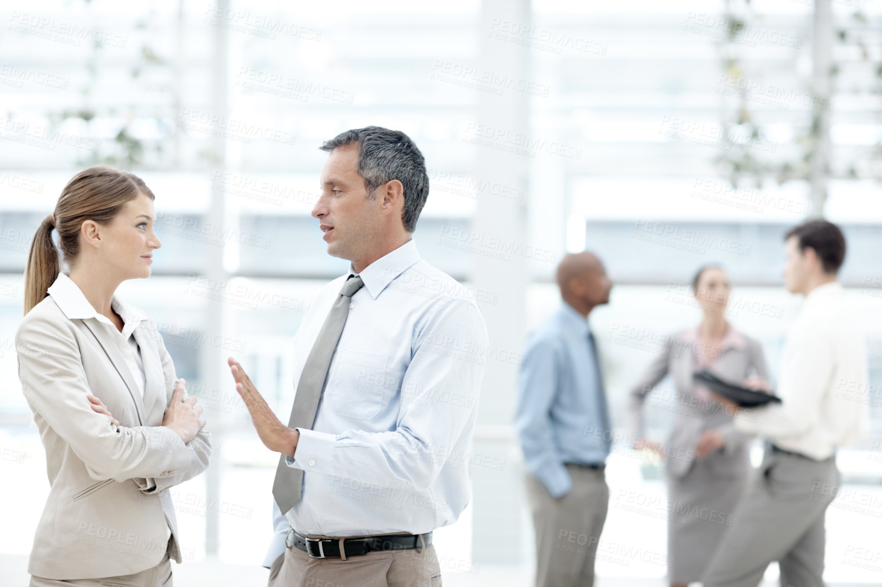 Buy stock photo Businesspeople having a discussion with their colleagues in the background