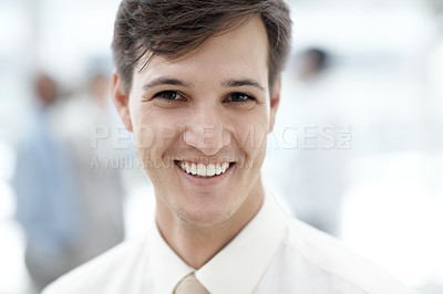 Buy stock photo Shot of a businessman standing in an office lobby with colleagues in the background