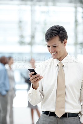 Buy stock photo Shot of a businessman standing in an office lobby with colleagues in the background