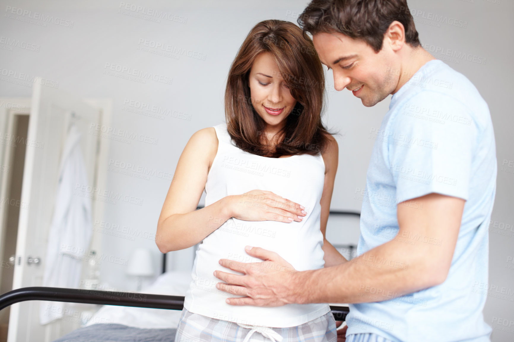 Buy stock photo Couple, happy and pregnancy with stomach, touch and bonding in home for future motherhood support. People, smile and healthy pregnant development for prenatal care, maternity and growth with relax