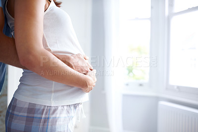 Buy stock photo Side view of a young womans pregnat belly being held by her and her boyfriend
