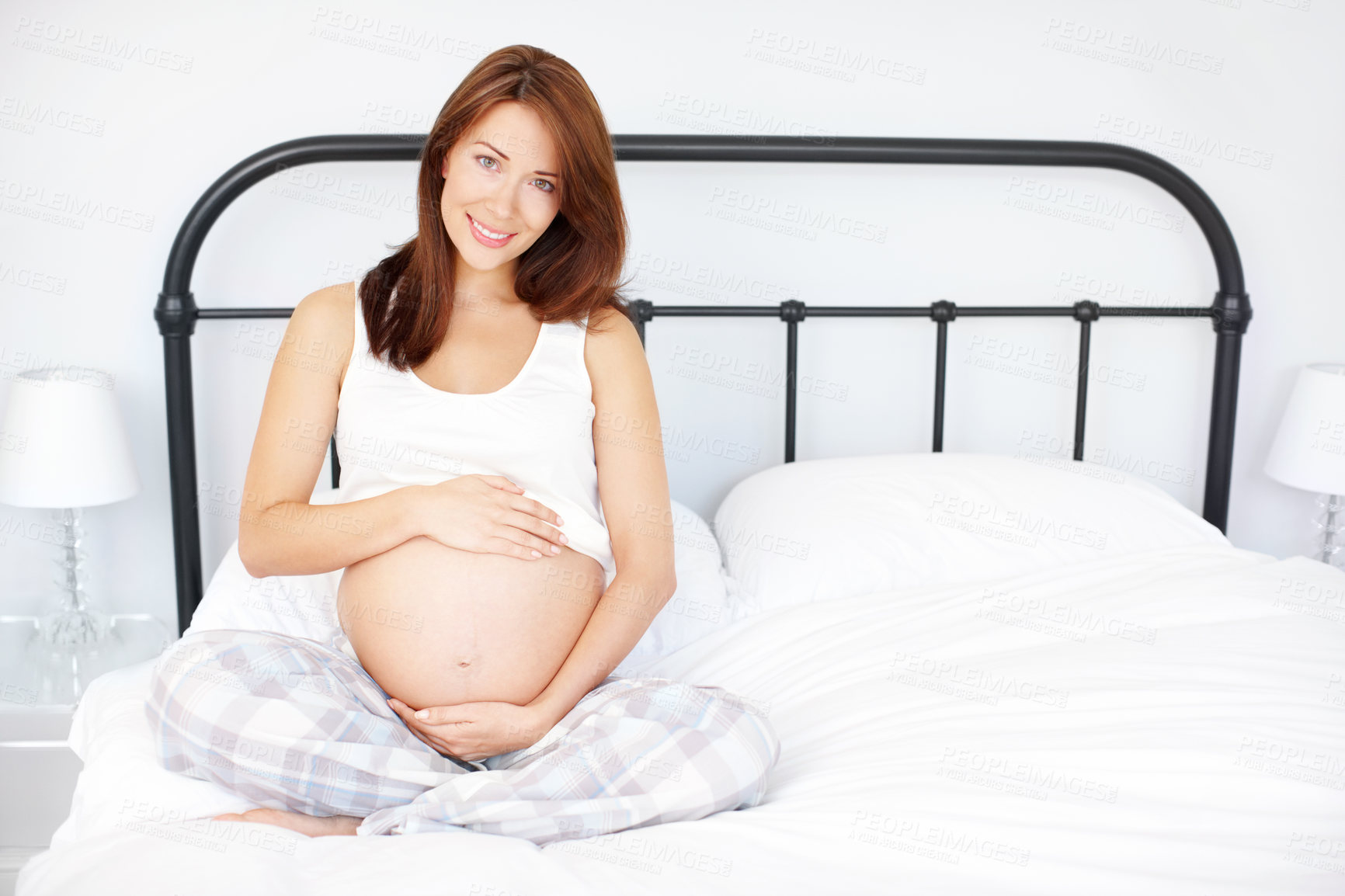 Buy stock photo Portrait, smile and pregnant woman touch stomach for maternity, health or prenatal care. Pregnancy, tummy and happy mother with baby expectation, future or love in bedroom to relax at home in Ireland