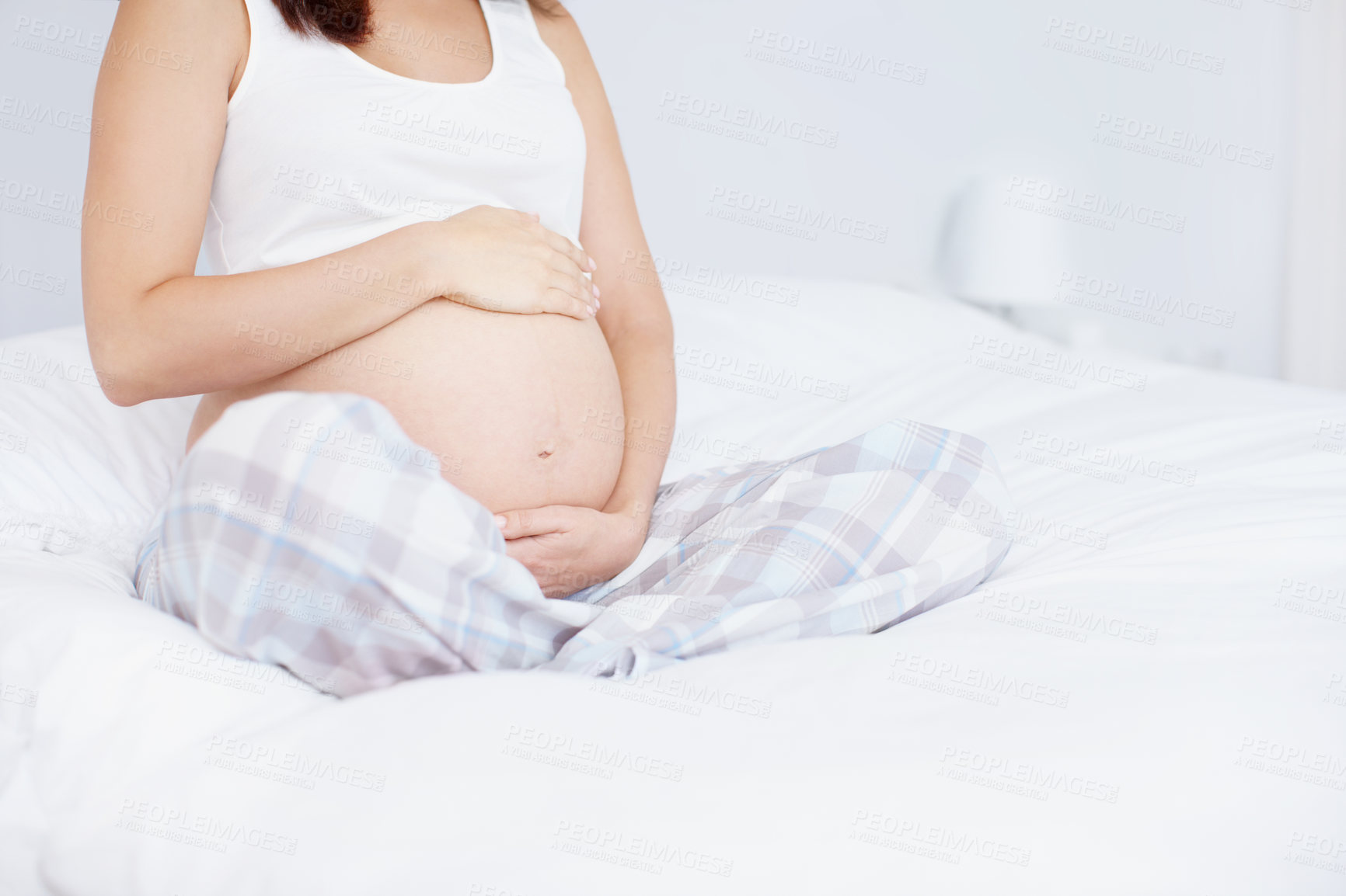 Buy stock photo Hands, bedroom and pregnant woman touch stomach for maternity, wellness and prenatal care. Pregnancy, mother and holding tummy for baby expectation, future development and growth at home to relax