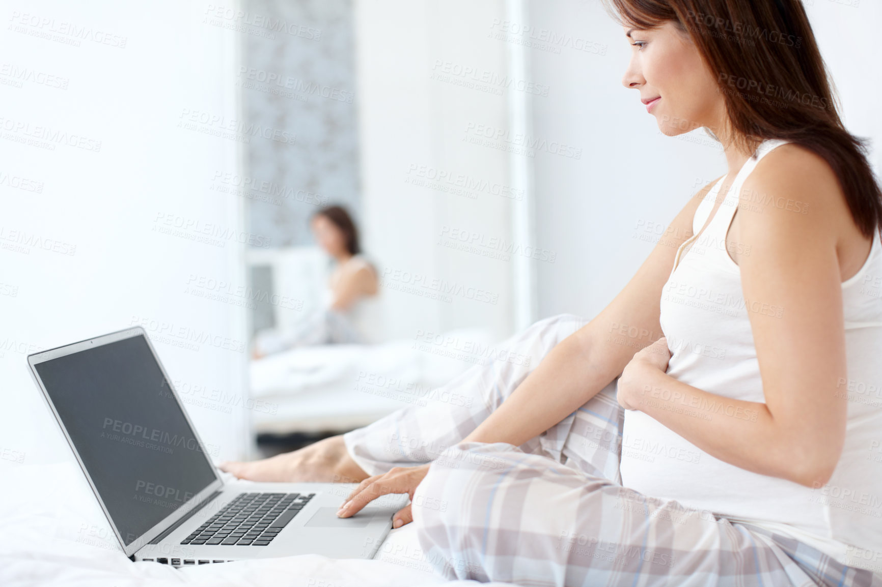 Buy stock photo Laptop, motherhood and pregnant woman for research, online knowledge and stomach comfort. Smile, baby and future mother with belly, pregnancy search and maternity leave to relax in home bedroom