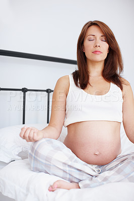 Buy stock photo A pregnant woman meditating on her bed - Copyspace