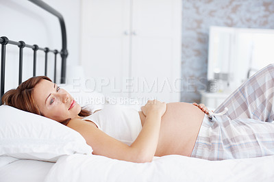 Buy stock photo A beautiful pregnant woman lying on her bed and reflecting - Copyspace