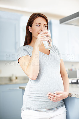 Buy stock photo Pregnant woman, thirsty and drinking water in home, nutrition and aqua for hydration in kitchen. Mother to be, maternity detox and mineral liquid for energy, health or refreshing beverage in glass