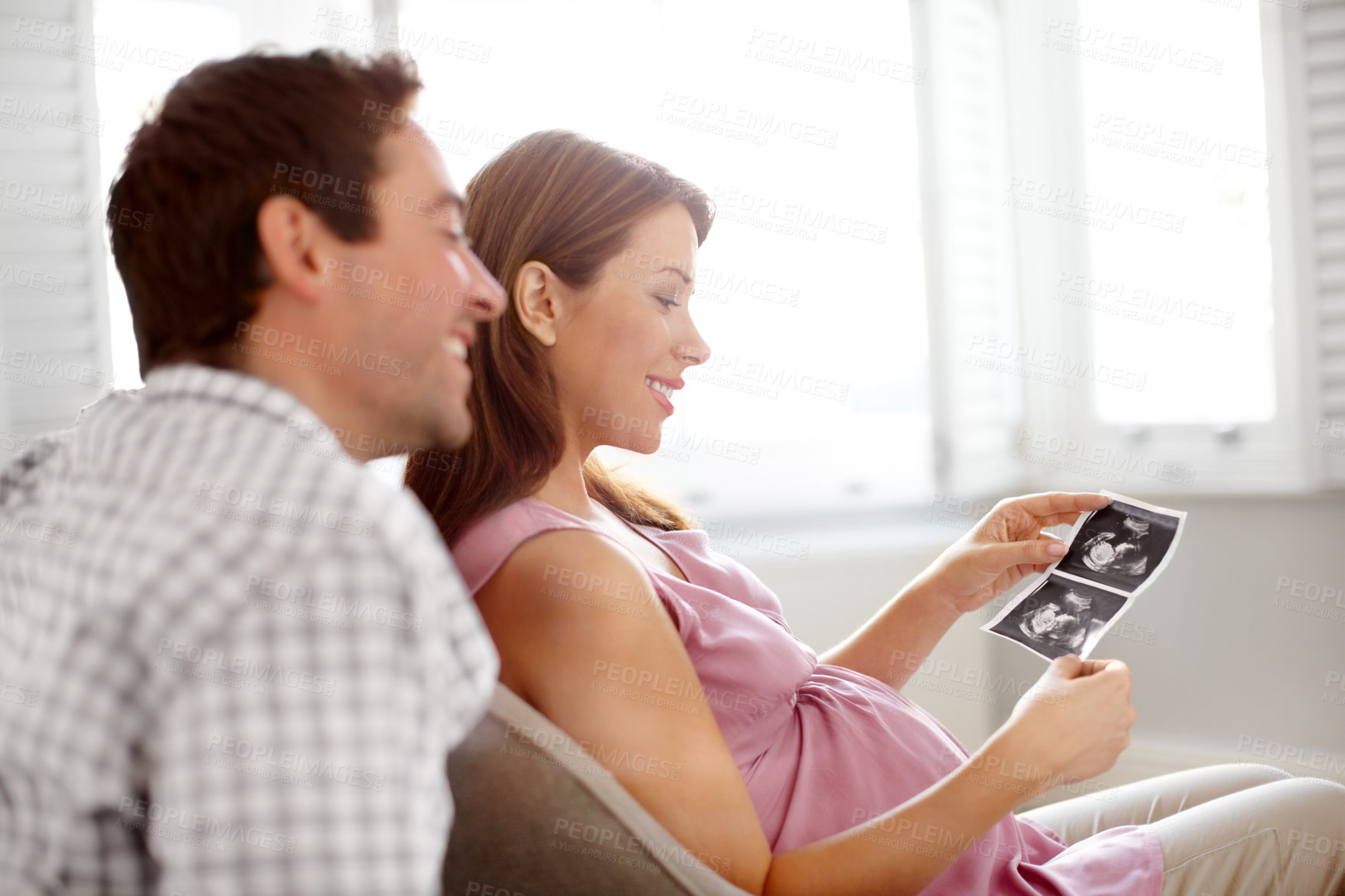 Buy stock photo Happy young couple looking at a image of their babies sonogram