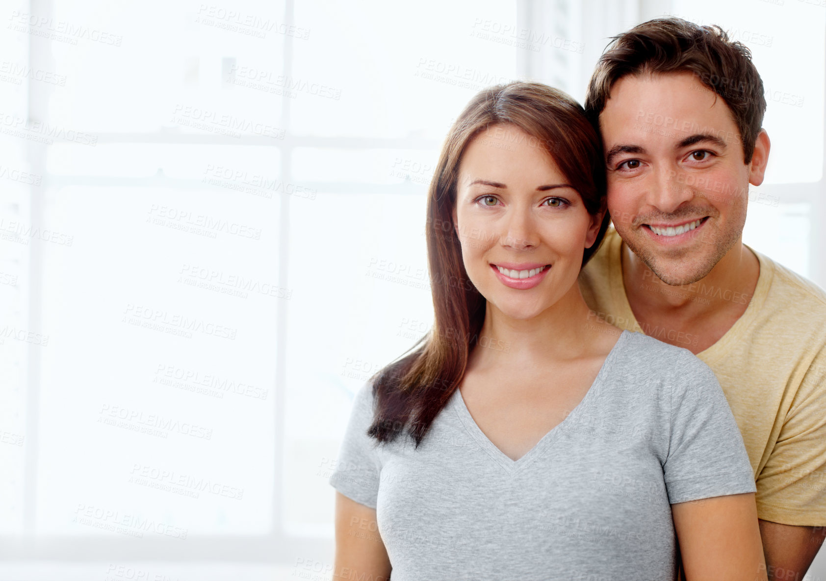Buy stock photo Portrait of an attractive young couple standing indoors together - Copyspace 