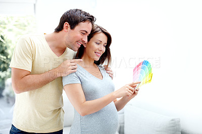 Buy stock photo Happy parents to be, picking out the right colour for their babys room