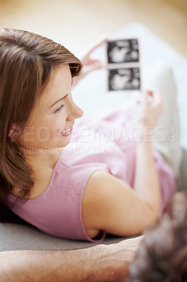 Buy stock photo A beautiful pregnant woman looking at ultrasound scans with her husband - Top-view