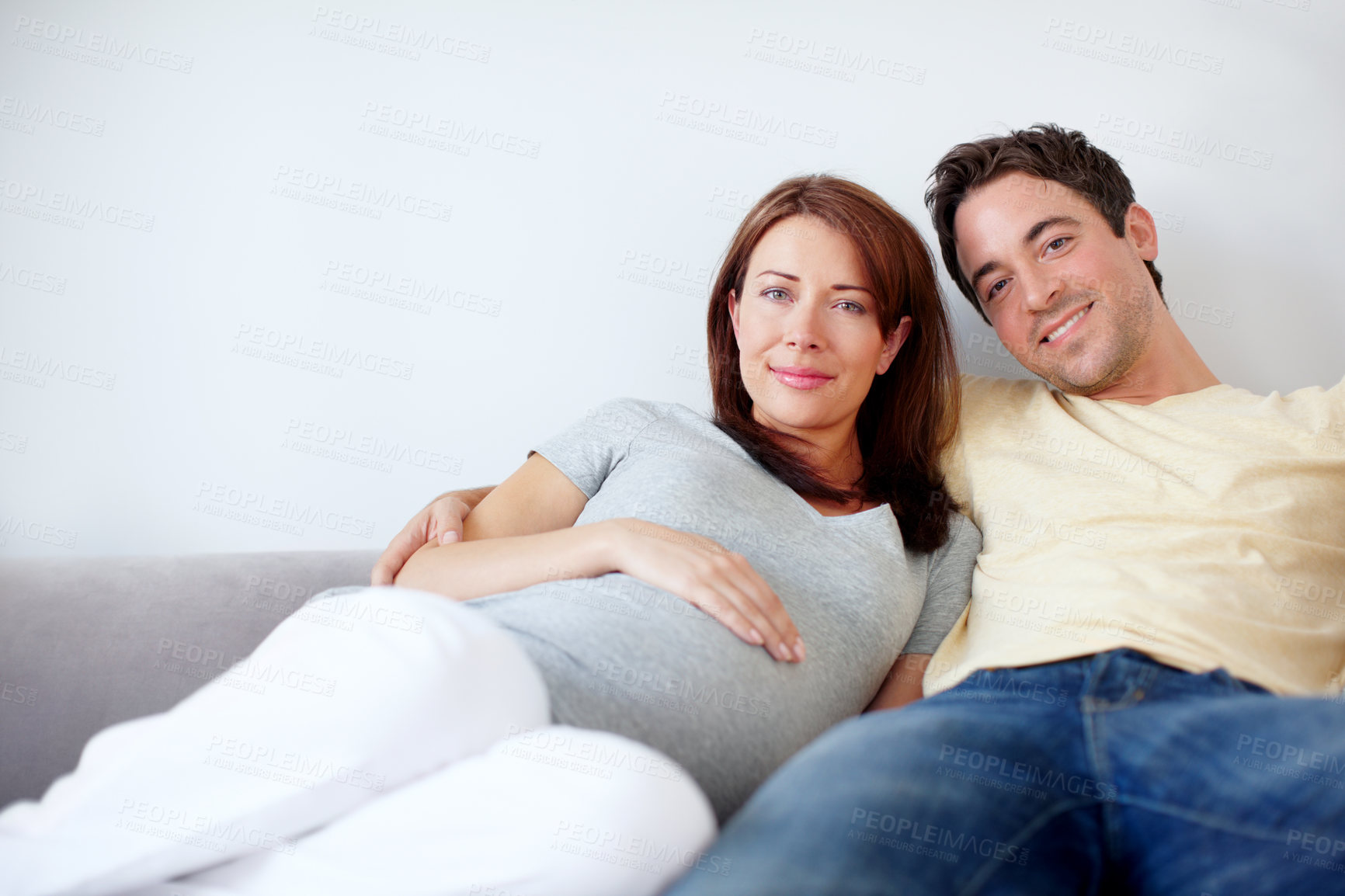 Buy stock photo Couple, home and portrait for pregnancy on sofa in living room on maternity break, bonding or relax. People, love and happy in relationship at apartment for support, trust and care with future