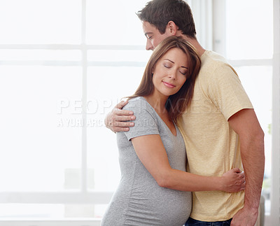 Buy stock photo A beautiful pregnant woman being embraced by her husband - Copyspace