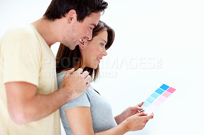 Buy stock photo An expecting couple looking over a blue and pink colour swatch for the baby's room