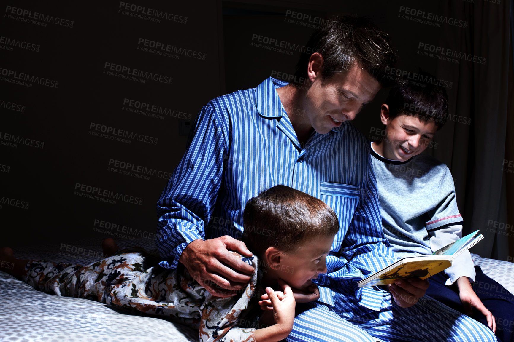 Buy stock photo Children, father and reading bedtime story, fantasy book or brothers learning in dark home at night. Happy kids, dad and storytelling in bedroom for education, fairytale and family bonding together