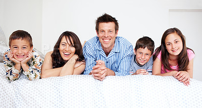 Buy stock photo A loving family of five lying in bed together wearing pajamas