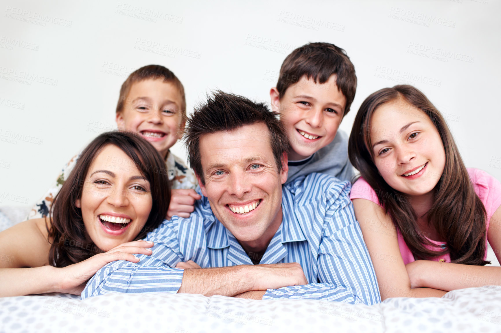 Buy stock photo A loving family of five lying in bed together wearing pajamas - Closeup