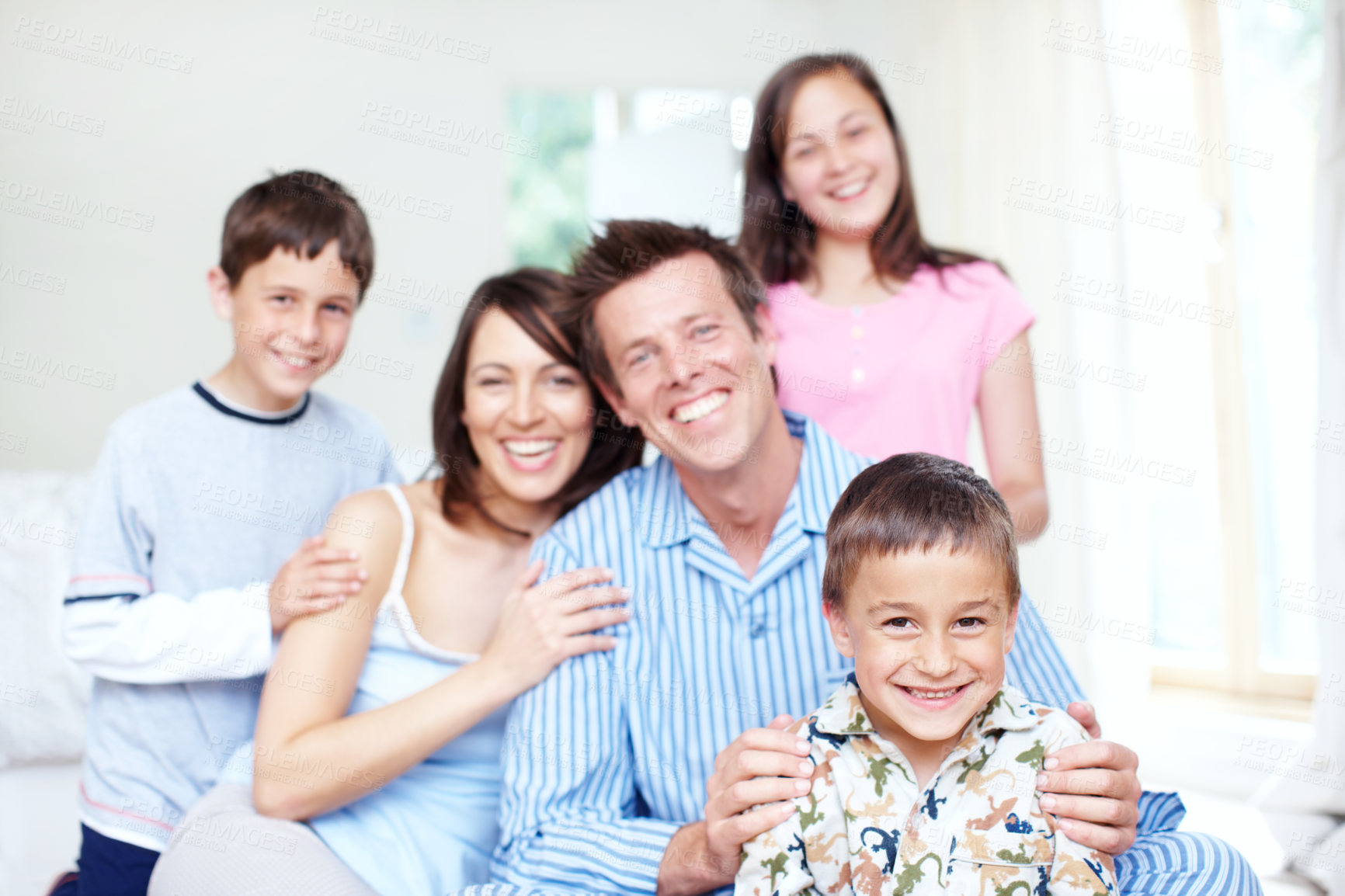 Buy stock photo Portrait of a cute little boy with his family sitting behind him happily