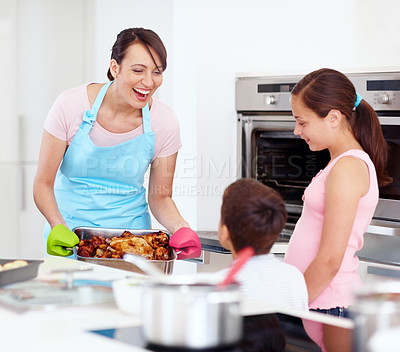 Buy stock photo Mother, kids and happy for food in kitchen with love, cooking and excited for roast at oven. Mom, children and smile in home with chicken, family lunch preparation and support for Thanksgiving meal