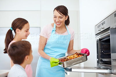 Buy stock photo Mother, kids or happy for food in kitchen with love, cooking or excited for roast at oven. Mom, children or chicken in home for learning, family meal preparation or smile for Thanksgiving celebration