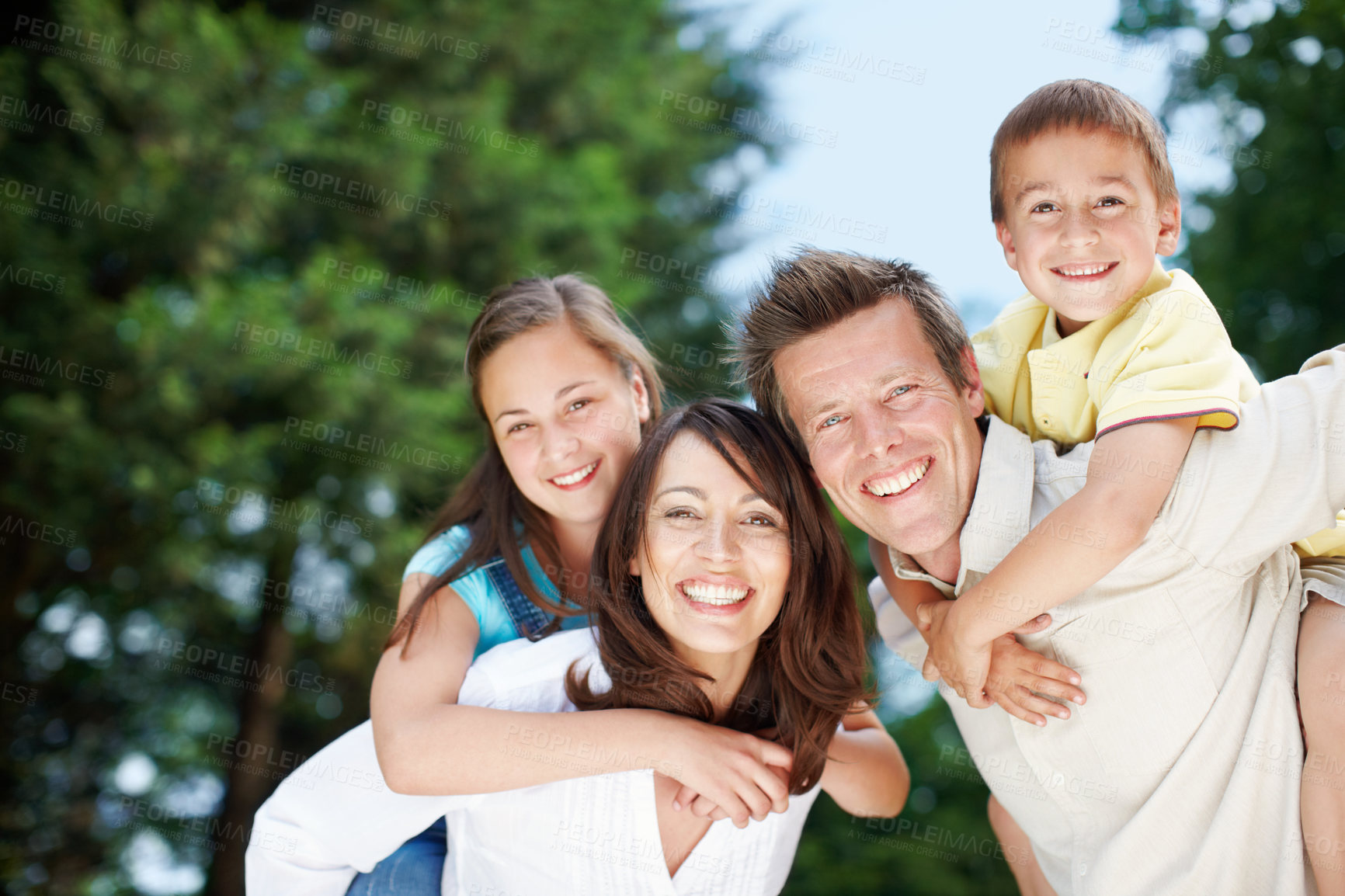 Buy stock photo Family, park and portrait outdoor with piggy back, game and smile with mom, dad and kids with fun. Bonding, love and care with happy youth and hug in nature with trees, weekend and break in garden