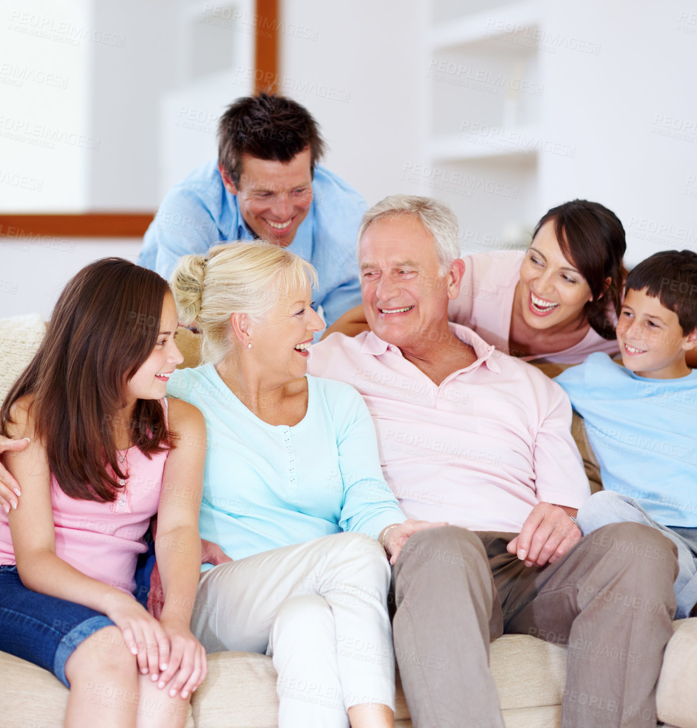 Buy stock photo Laughing,  home and parents with children and grandparents together with care on sofa. Family generations, happy and smile with love, bonding and support with hug relax in living room on weekend