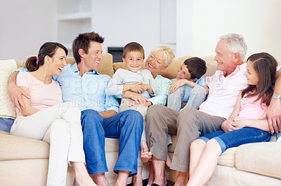 Buy stock photo Three generations of family sitting together affectionately on the lounge couch